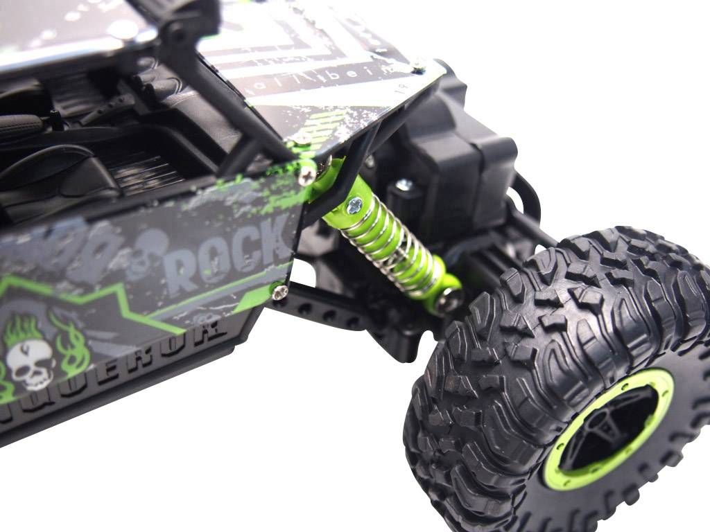 Nahaufnahme eines grünen und schwarzen ferngesteuerten Autos mit grobstolligen Reifen und sichtbaren Stoßdämpfern.