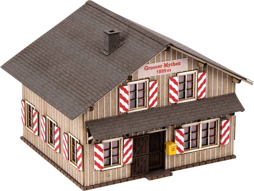 Modell eines Holzhauses mit dem Aufdruck 'Grosser Mythen 1899 m'. An der Fassade sind rot-weiß gestreifte Fensterläden.