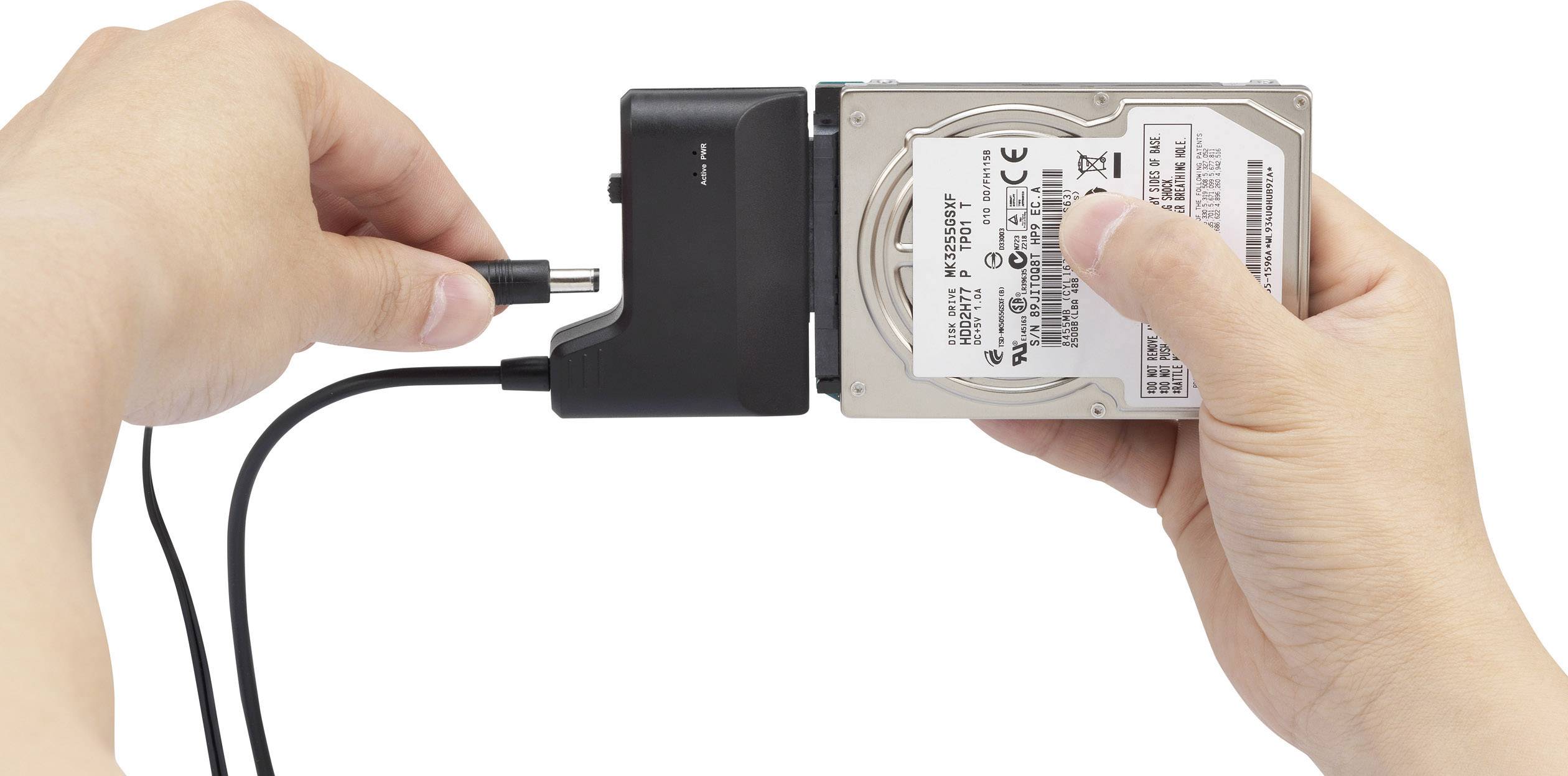 Zwei Hände halten eine externe Festplatte und ein Ladekabel. Die Festplatte wird zum Anschließen an den Computer vorbereitet.