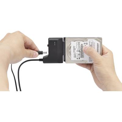Zwei Hände halten eine externe Festplatte und ein Ladekabel. Die Festplatte wird zum Anschließen an den Computer vorbereitet.