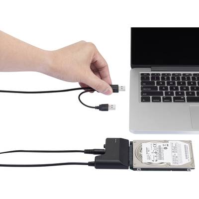Eine Hand hält ein USB-Kabel über einem Laptop, daneben externe Festplatte, verbunden mit Adapter an zweites USB-Kabel.