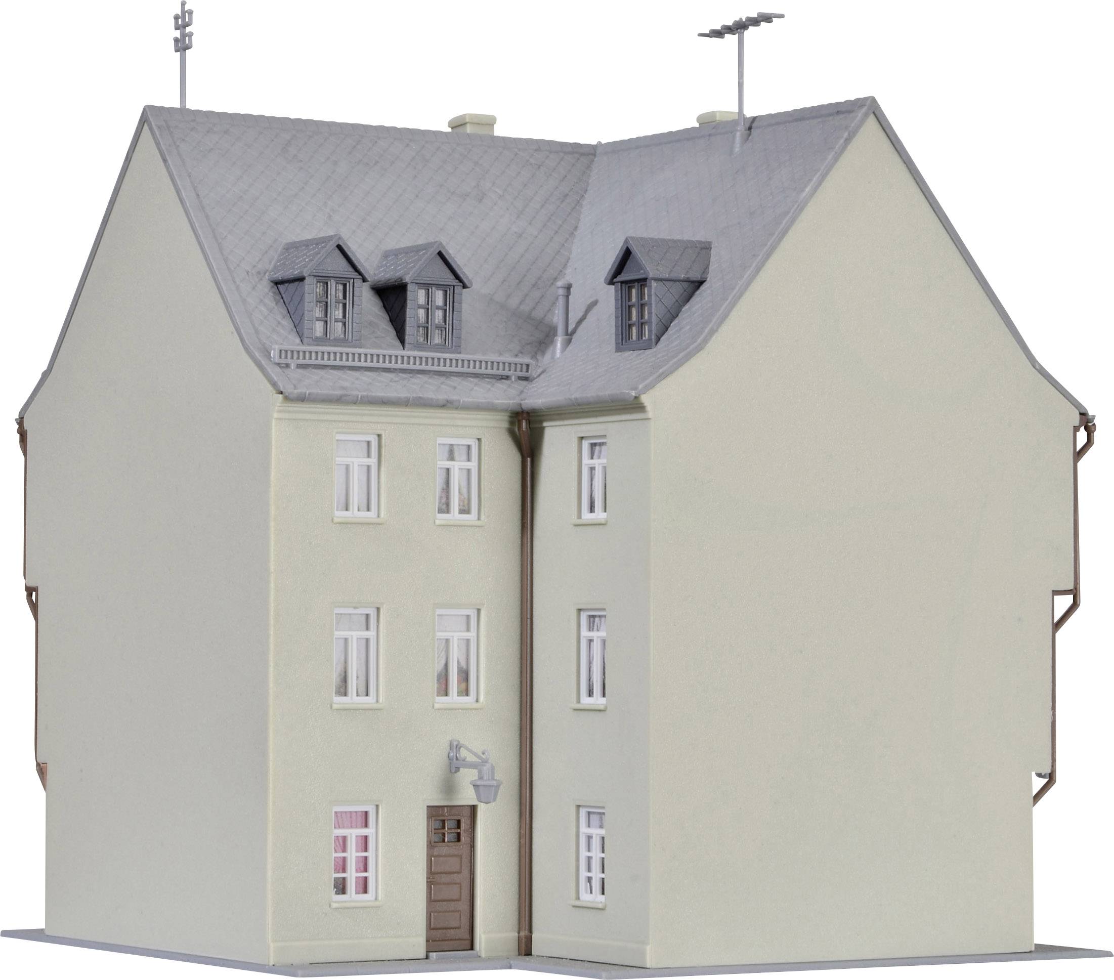 Zweistöckiges, graues Wohnhaus mit Dachgauben und Antennen auf dem Dach, mehreren Fenstern und einer braunen Eingangstür.