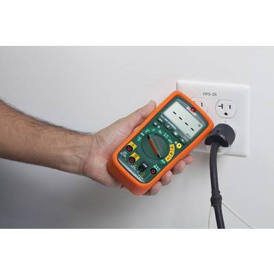 Eine Hand hält ein Multimeter, das mit einer Steckdose verbunden ist, um elektrische Messungen durchzuführen.