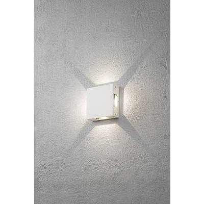 Weiße, quadratische Wandleuchte leuchtet nach oben und unten auf einer grauen Wand. Schritteffekt sichtbar durch Lichtstrahlen.