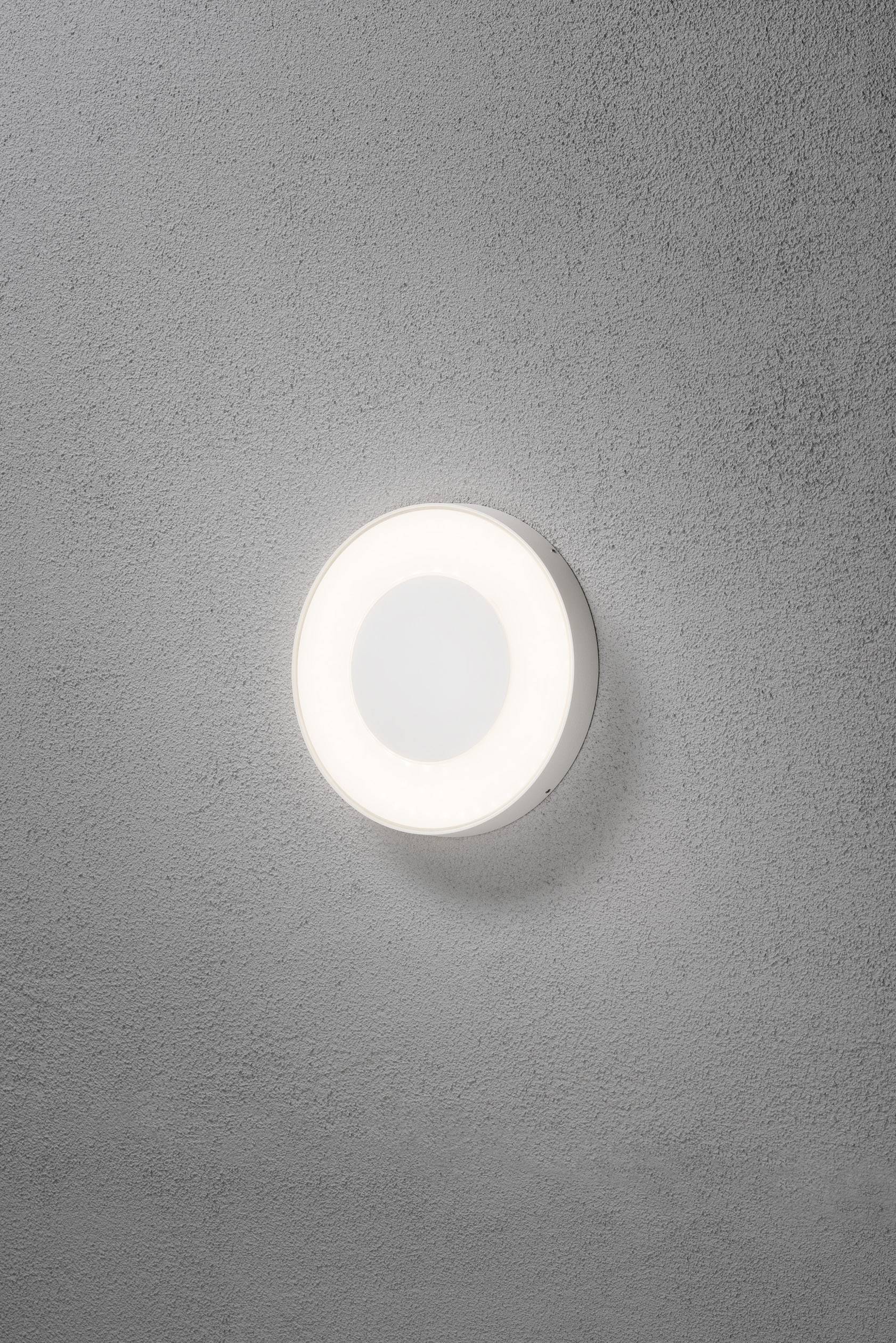 Runde, moderne Wandlampe mit weißem Licht auf grauer Betonwand.
