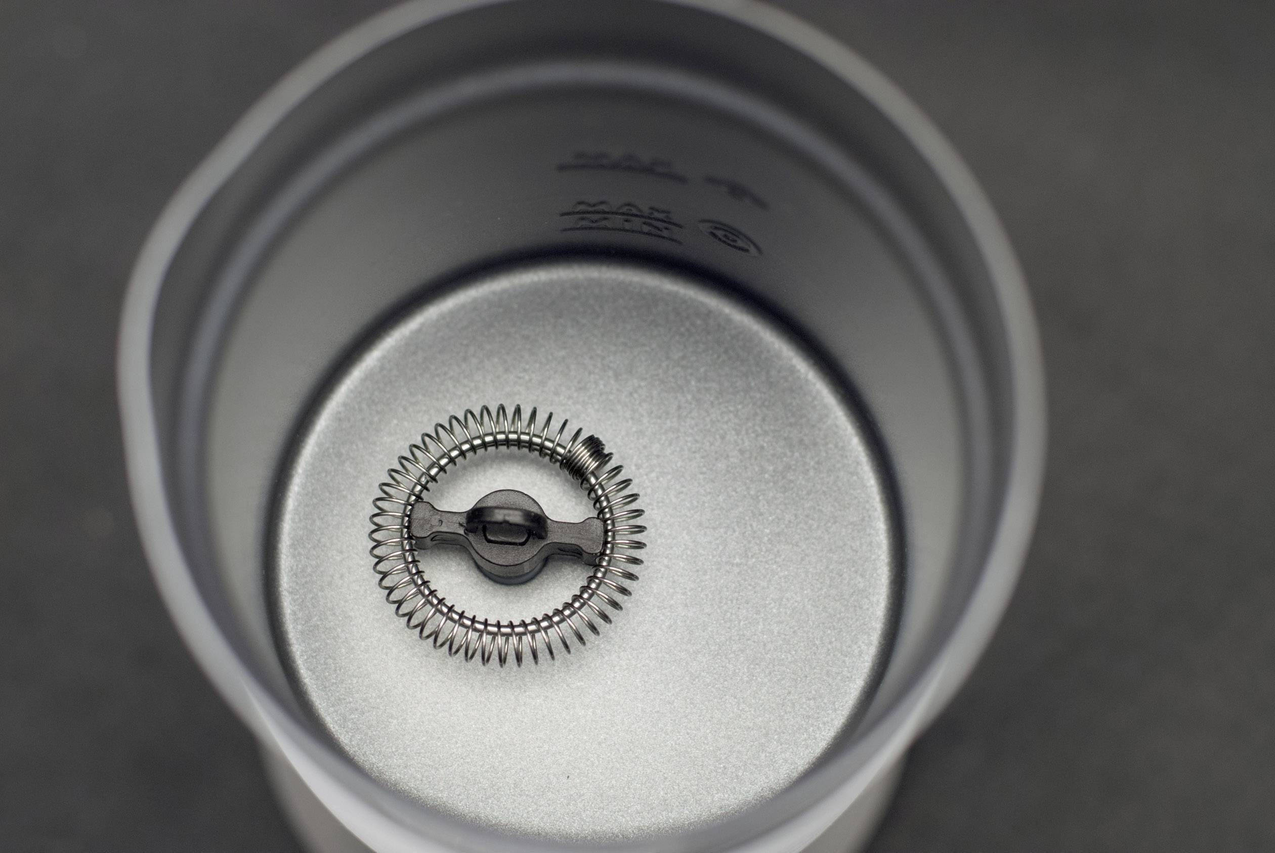 Ein Metallzahnrad befindet sich in einer zylindrischen grauen Metallstruktur. Die Umgebung wirkt industriell und mechanisch.