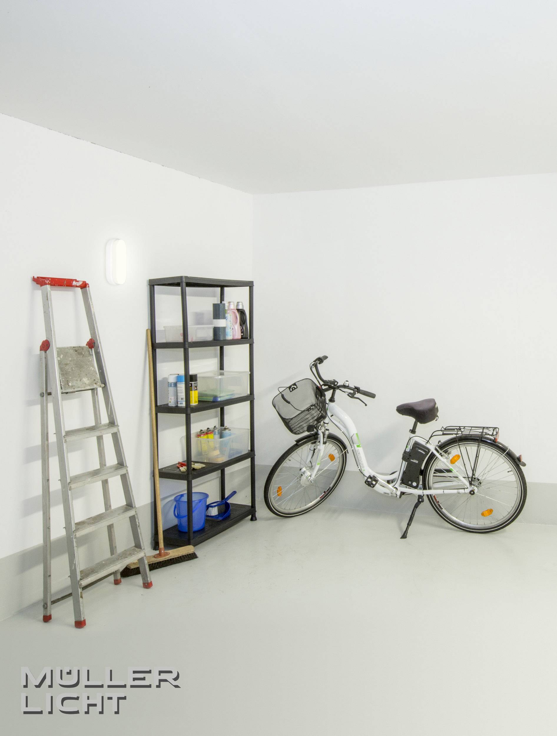 Ein Fahrrad steht in einer hell beleuchteten Ecke eines Raumes neben einem schwarzen Regal voll mit Reinigungsutensilien und einer Leiter.