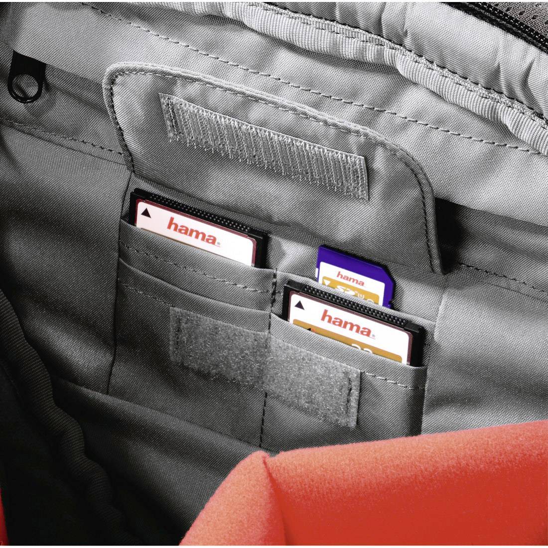 Eine Tasche aus grauem Stoff mit mehreren Einschüben für Speicherkarten. Die Karten sind mit 'hama'-Etiketten gekennzeichnet.