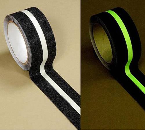 Eine Rolle schwarzes Klebeband mit einem hellen Streifen, der aufleuchtet. Links im Licht, rechts im Dunkeln leuchtend.