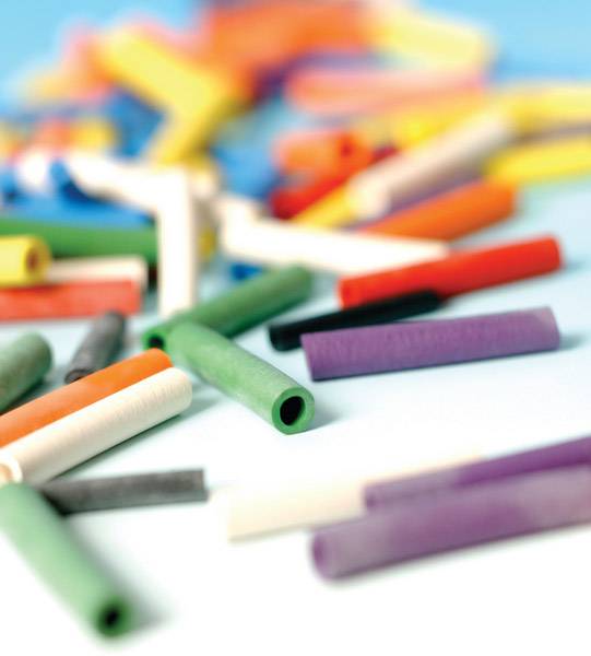 Bunte Kreide in verschiedenen Farben verstreut auf einem blauen Hintergrund, unscharf im Vordergrund für einen kreativen Eindruck.