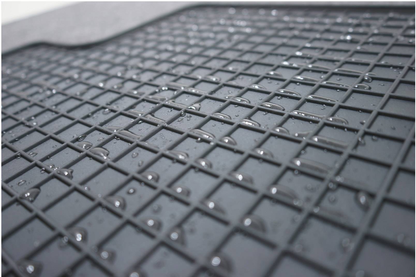 Eine Gummimatte mit Wassertropfen darauf, die auf einer Oberfläche liegt, zeigt wasserabweisendes Material.