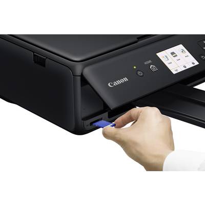 Eine Hand steckt eine blaue Speicherkarte in einen schwarzen Drucker ein. Der Drucker hat ein Display mit Symbolen.