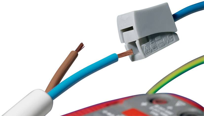 Ein braunes und ein blaues Kabel werden mit einer Wago-Klemme verbunden. Kabelenden sind teils freigelegt. Hintergrund zeigt Werkzeug.