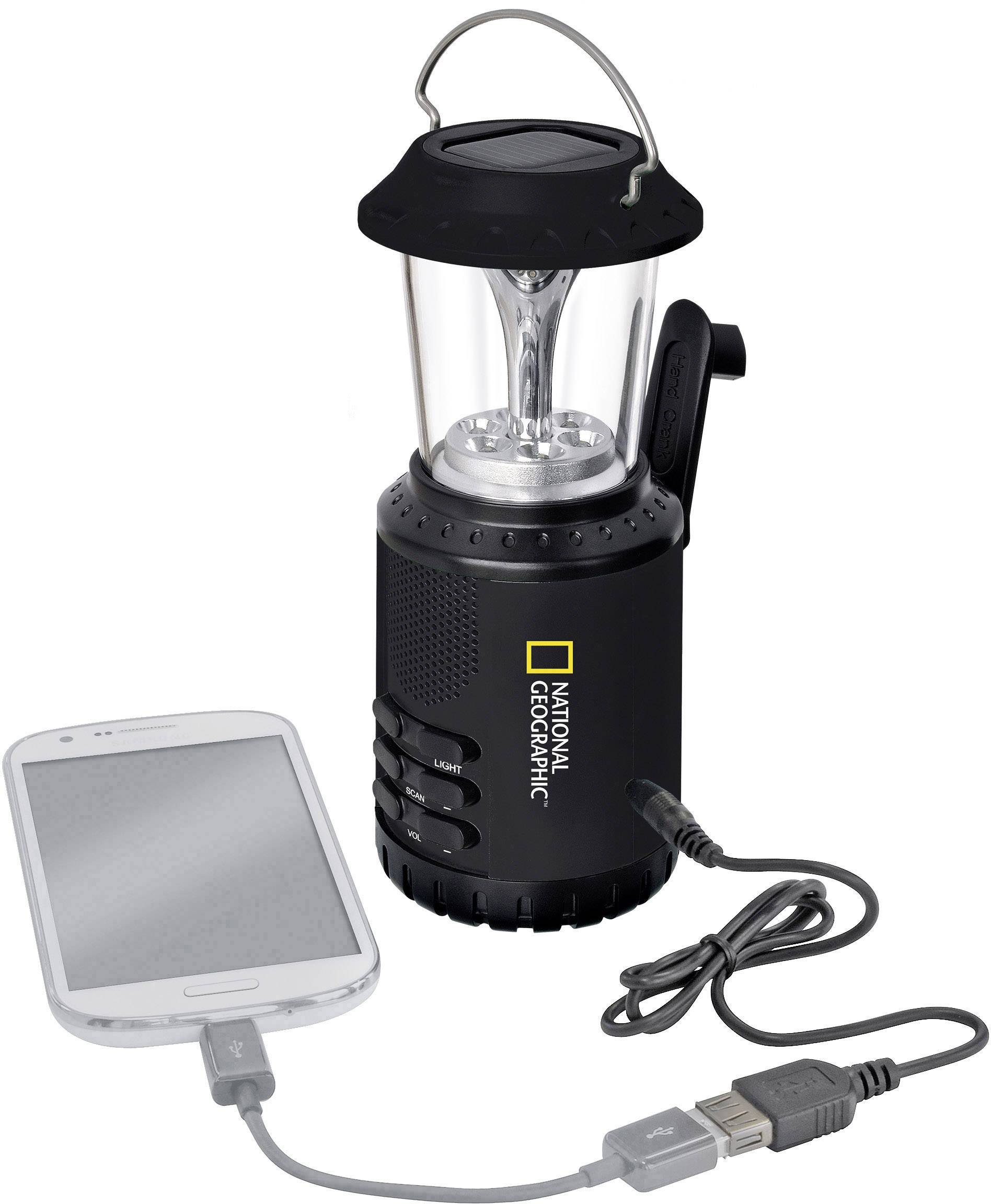 Eine schwarze Taschenlampe mit Kurbel und eingebautem USB-Anschluss lädt ein Smartphone auf. Logo von National Geographic sichtbar.
