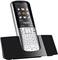 Kabelloses DECT-Telefon auf Ladestation, silbergraues Design, großes Tastenfeld, beleuchtetes Display mit Symbolen für Anrufe, Nachrichten und Einstellungen.