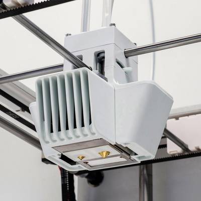Ein 3D-Drucker-Extruderkopf aus weißem Kunststoff und Metall in Nahaufnahme, montiert auf einer Schiene, bereit zum Drucken.