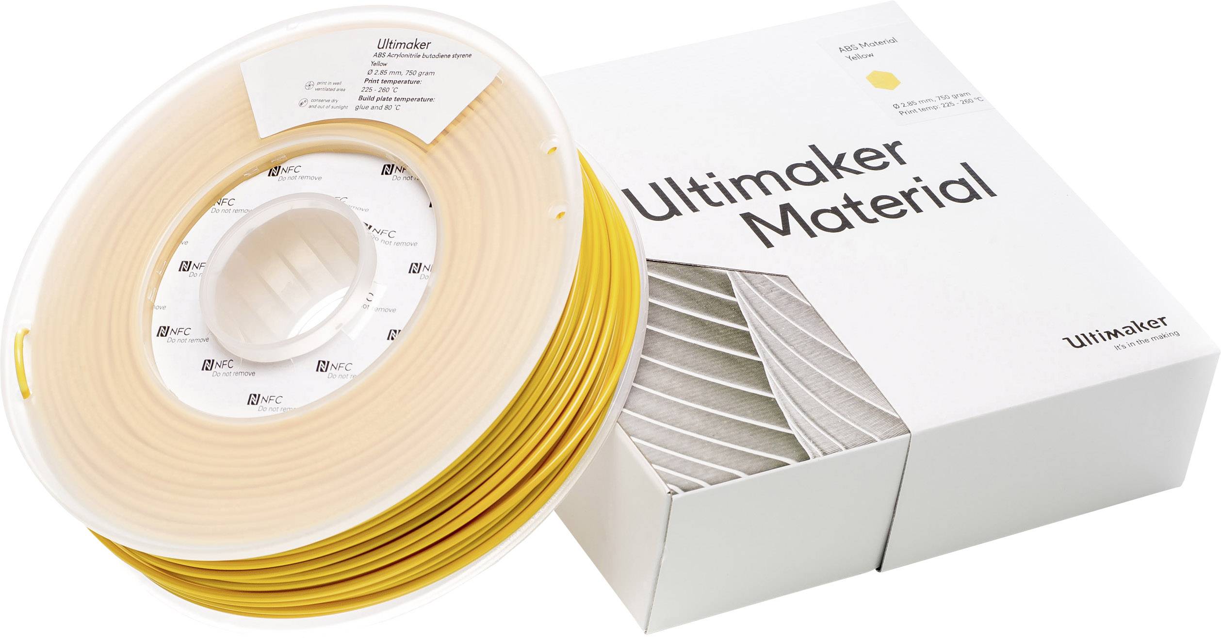Eine Rolle gelbes 3D-Druckfilament neben einer weißen Schachtel mit der Aufschrift 'Ultimaker Material'.