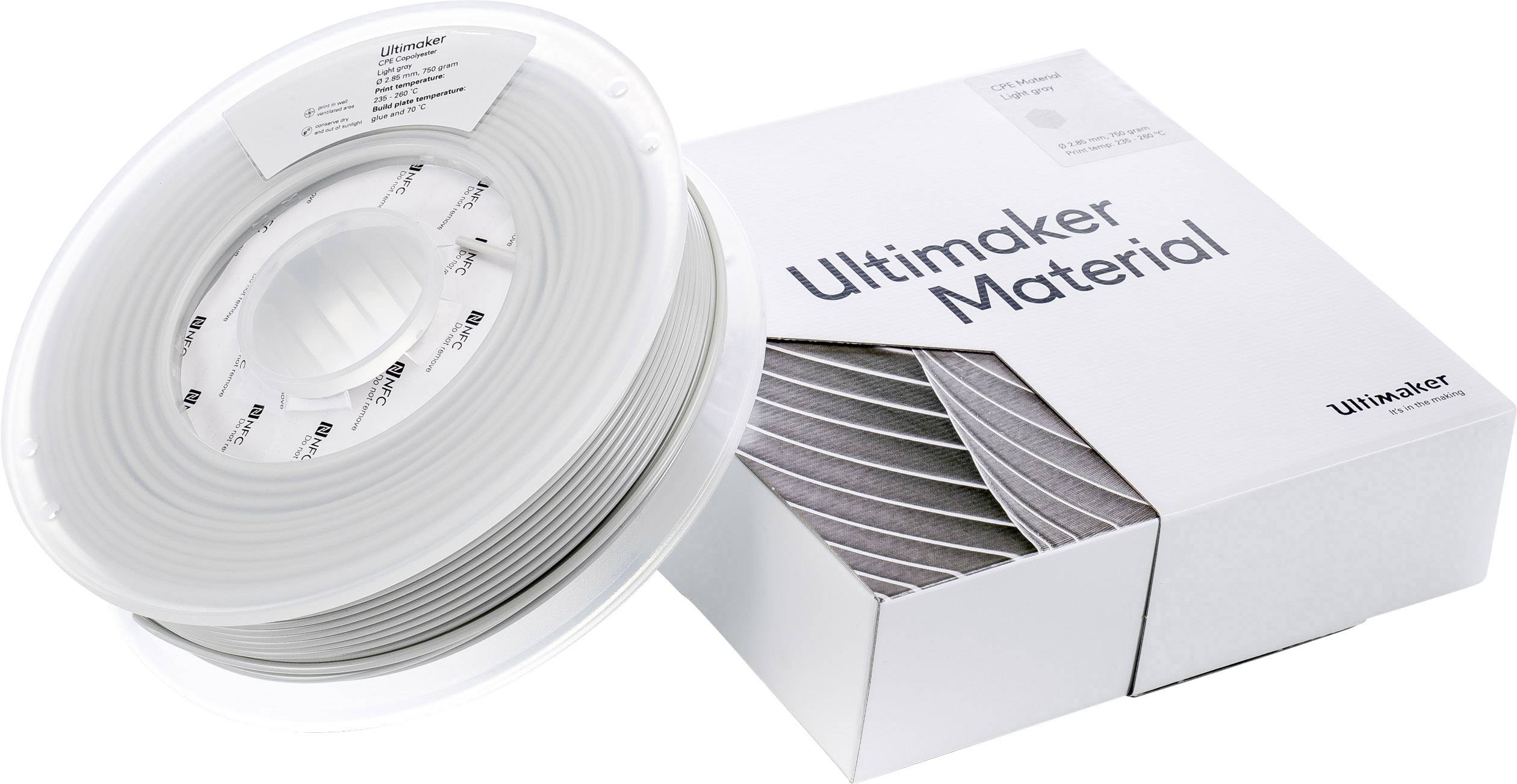 3D-Drucker-Filament-Spule aus grauem Material neben einer passenden Verpackung mit der Aufschrift 'Ultimaker Material'.