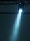 Ein heller Scheinwerfer strahlt von oben auf eine neutrale, leere Fläche, erzeugt einen konzentrierten Lichtkegel vor einem dunklen Hintergrund.
