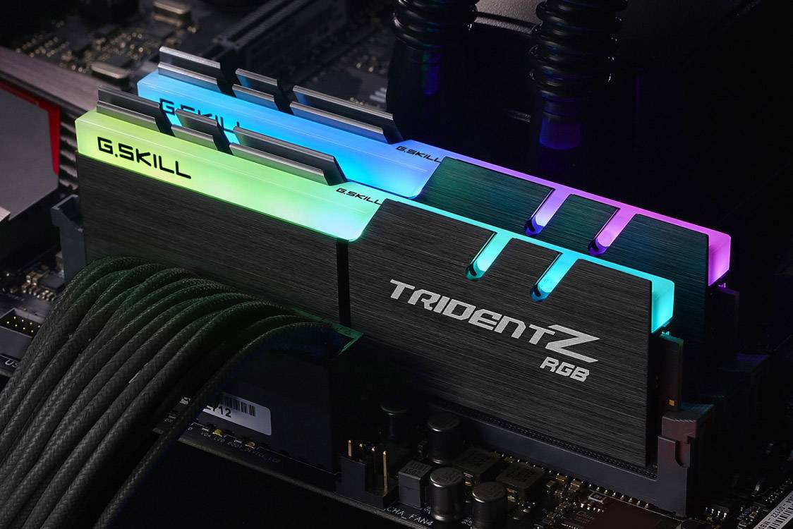 Zwei beleuchtete RAM-Module 'G.SKILL Trident Z RGB' in einem Computer, mit mehreren Farben beleuchtet, eingebaut auf einem Mainboard.