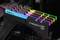 Vier G.Skill Trident Z RGB RAM-Module mit leuchtenden LEDs in verschiedenen Farben sind in einem Computer-Motherboard installiert.