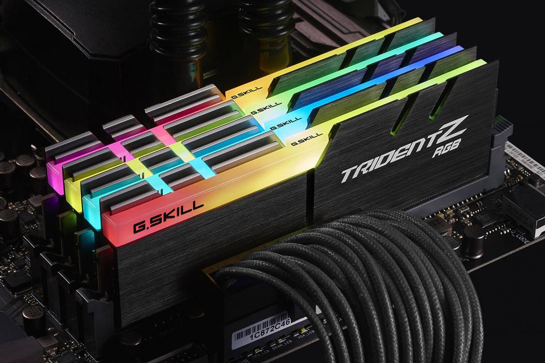 Ein Motherboard mit installierten, mehrfarbig leuchtenden RAM-Modulen der Marke G.SKILL, Modell Trident Z RGB.