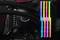 Ein Computer-Motherboard mit beleuchtetem, farbigem RGB-RAM. Vier RAM-Riegel leuchten in verschiedenen Farben.