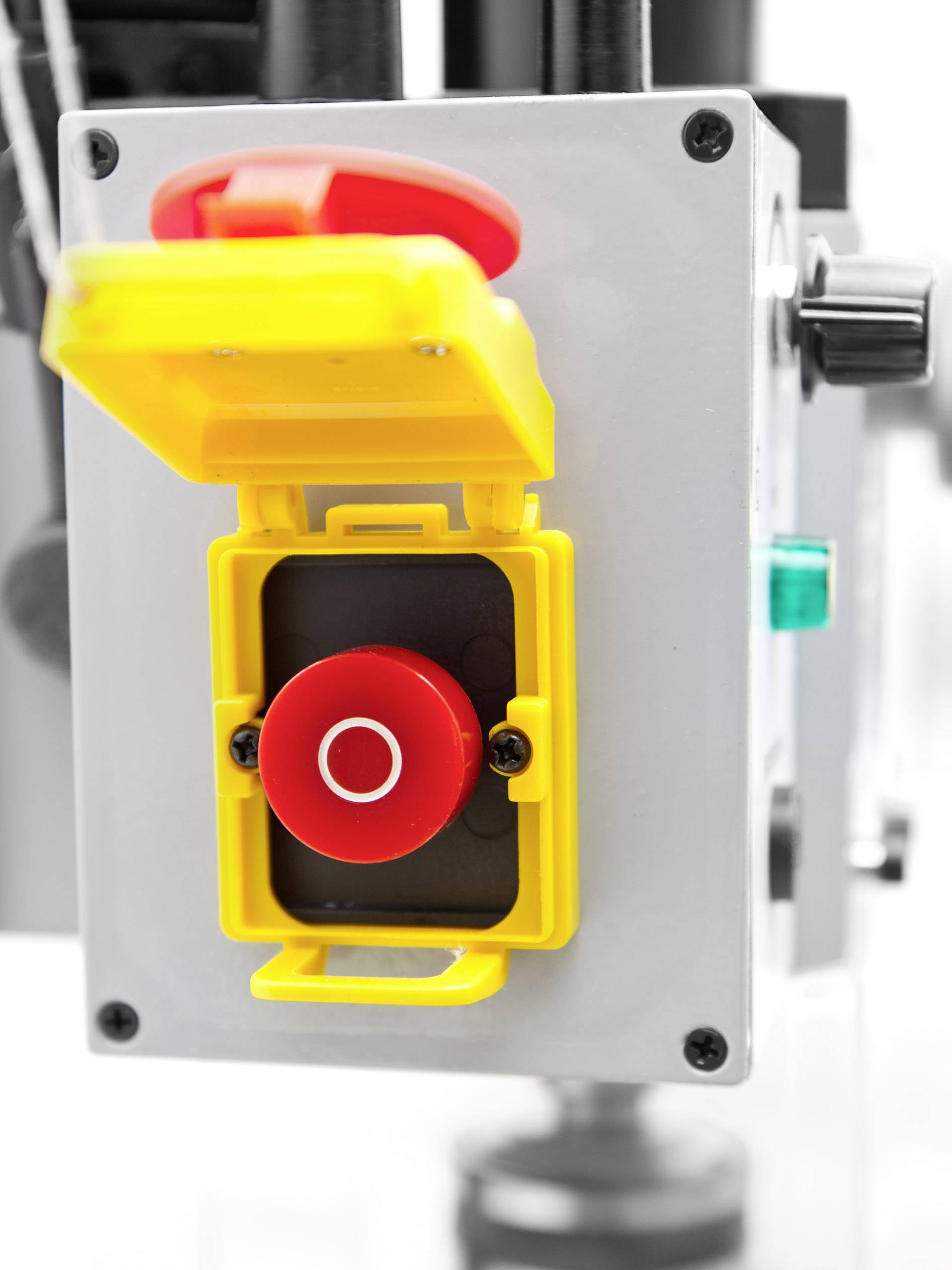 Gelber Gehäusedeckel geöffnet, roter Not-Aus-Knopf sichtbar auf einer Maschine zur schnellen Abschaltung in Notfällen.
