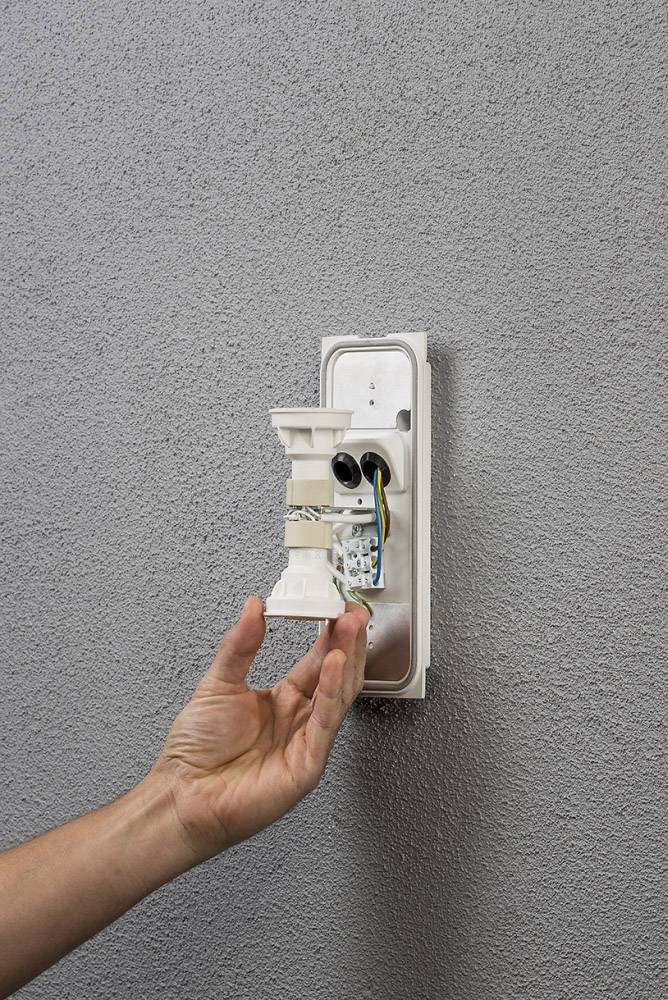 Hand montiert Halterung an der Wand. Elektrische Drähte sind sichtbar.