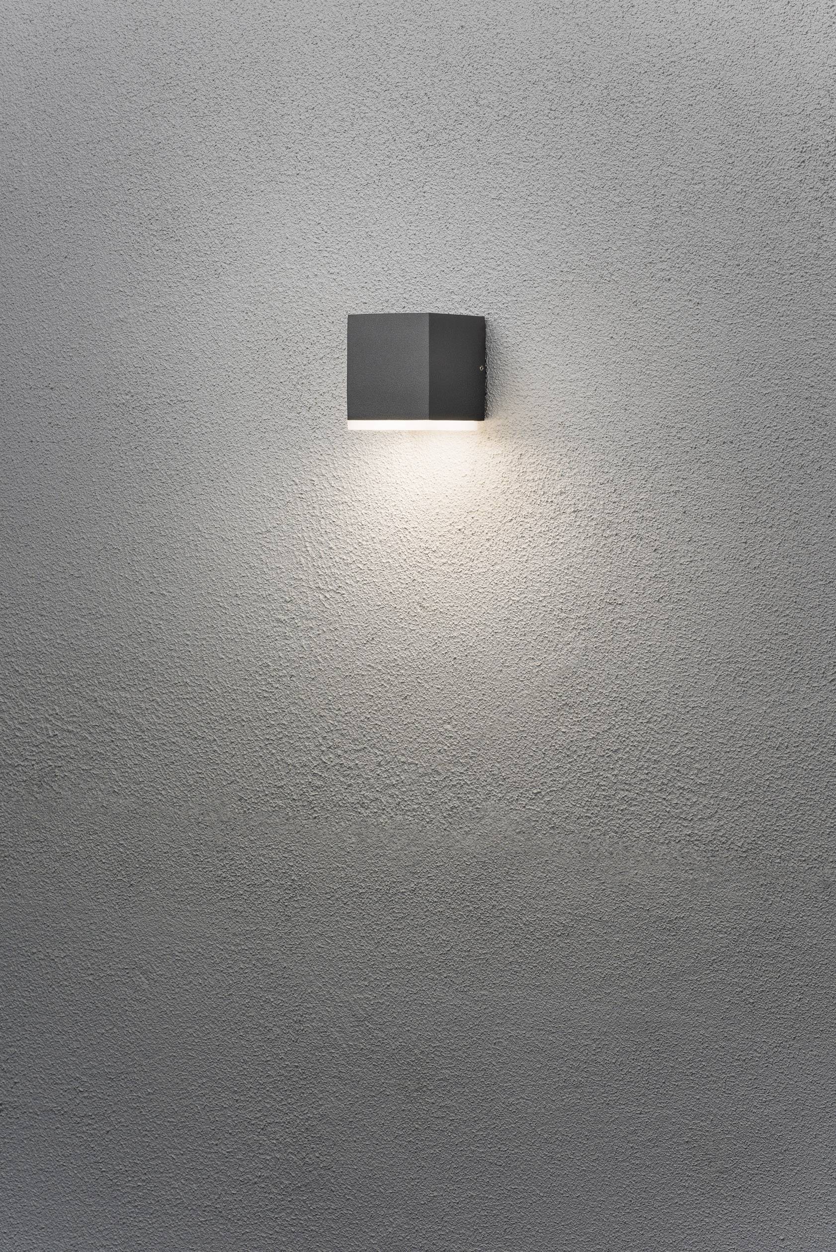 Wandleuchte mit modernem, quadratischem Design leuchtet gleichmäßig an grauer strukturierten Wand.