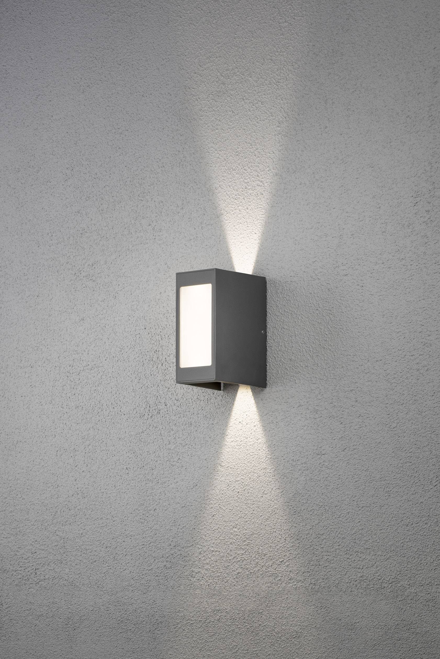Außenleuchte an einer Wand, rechteckig mit modernem Design, leuchtet nach oben und unten, erzeugt dekorative Lichtkegel.