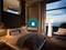 Ein modernes Schlafzimmer mit großem Bett und Lampe, bietet Blick auf den Ozean durch ein Fenster. Der Raum wirkt beruhigend und luxuriös.