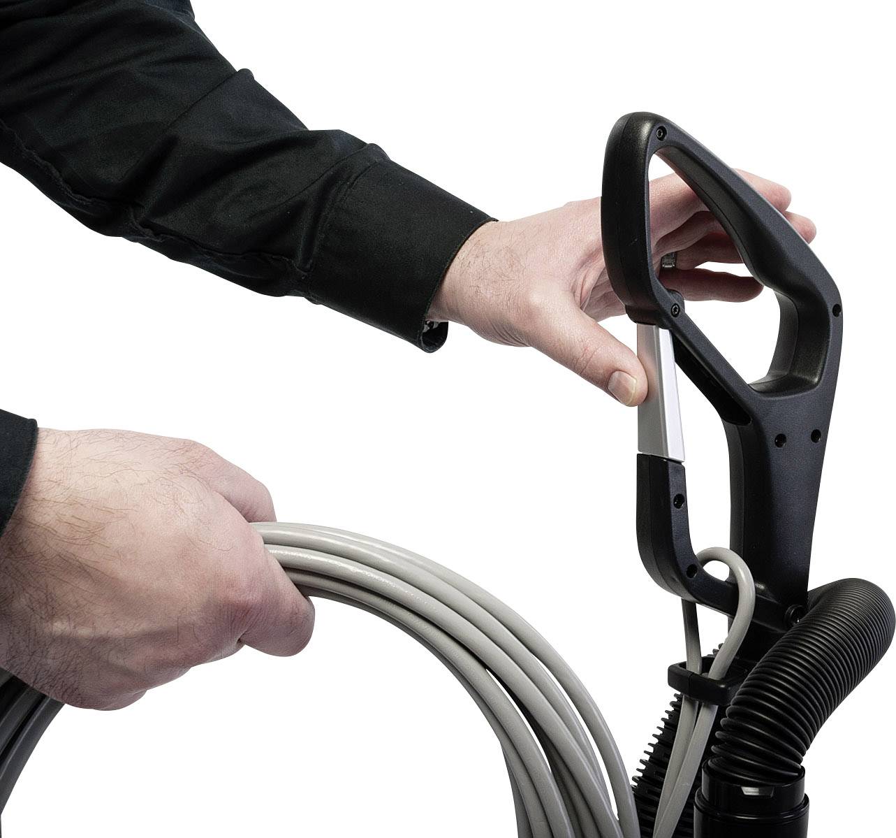 Eine Person wickelt das Kabel eines Staubsaugers um den Handgriff, bereit zum Verstauen.