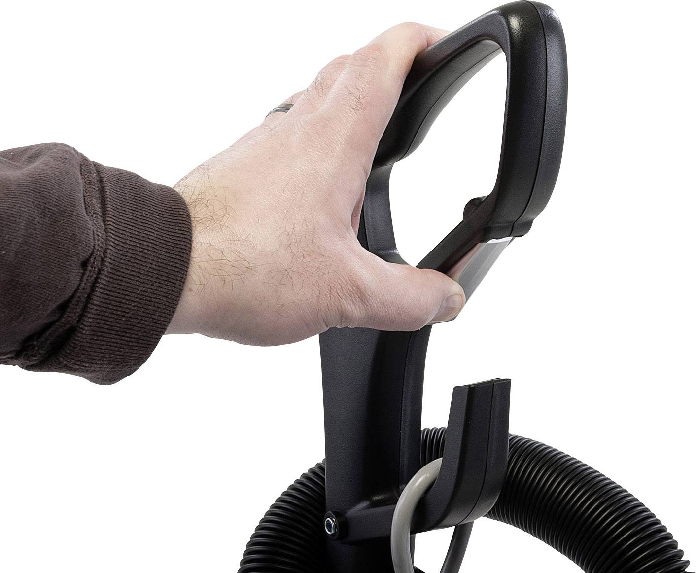 Eine Hand greift den Griff eines Staubsaugers. Ein Rohr ist mit dem Griff verbunden, und ein schwarzer Schlauch ist teilweise sichtbar.