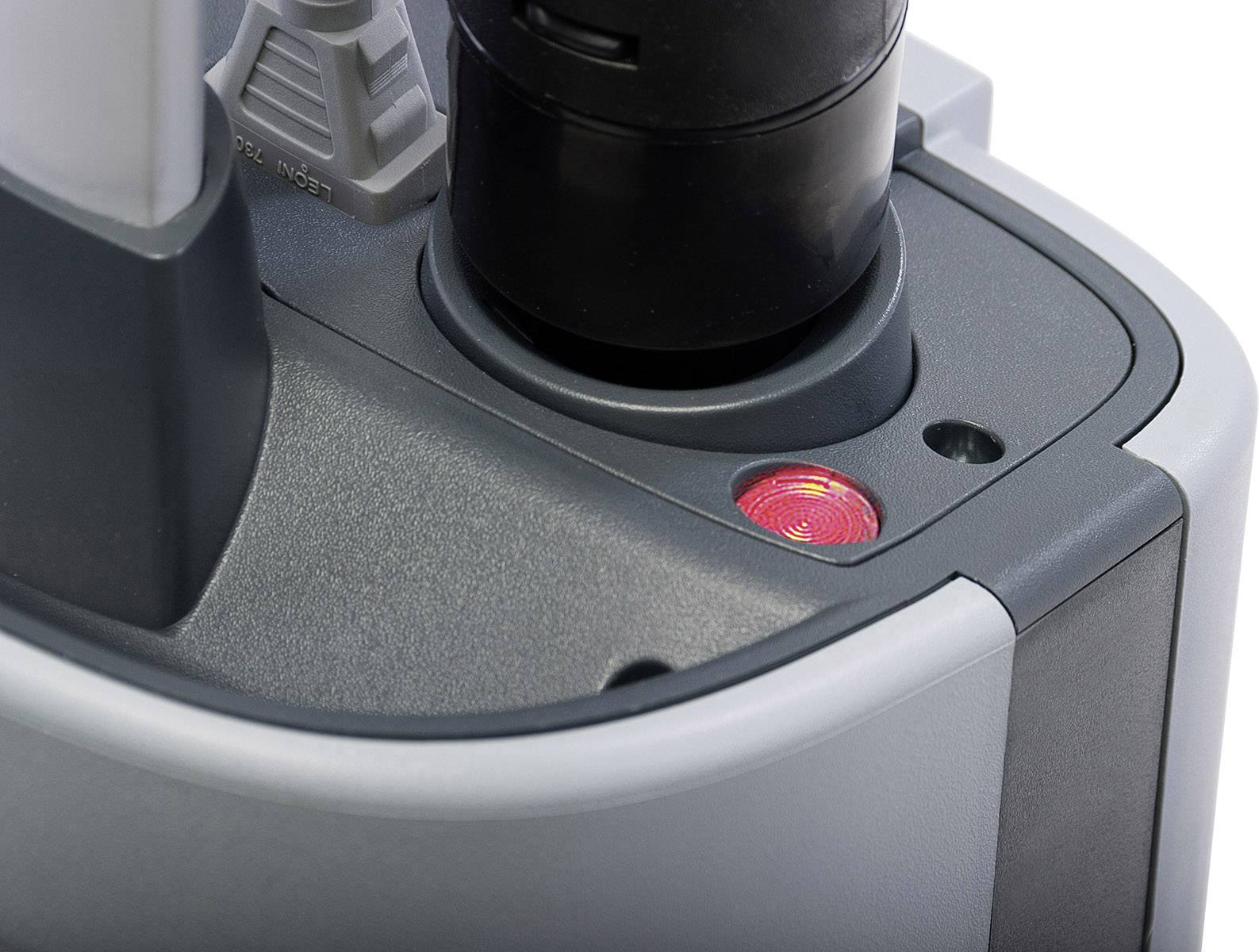 Roter Indikator auf einem grauen elektrischen Gerät leuchtet, zeigt Betriebsbereitschaft oder Ladevorgang an.