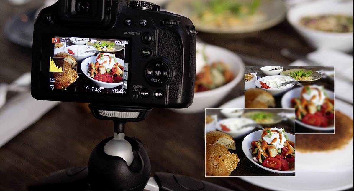 Eine Kamera auf einem Stativ zeigt das Bild eines Tischs mit Essen. Auf dem Display sind Nahaufnahmen von Speisen zu sehen.