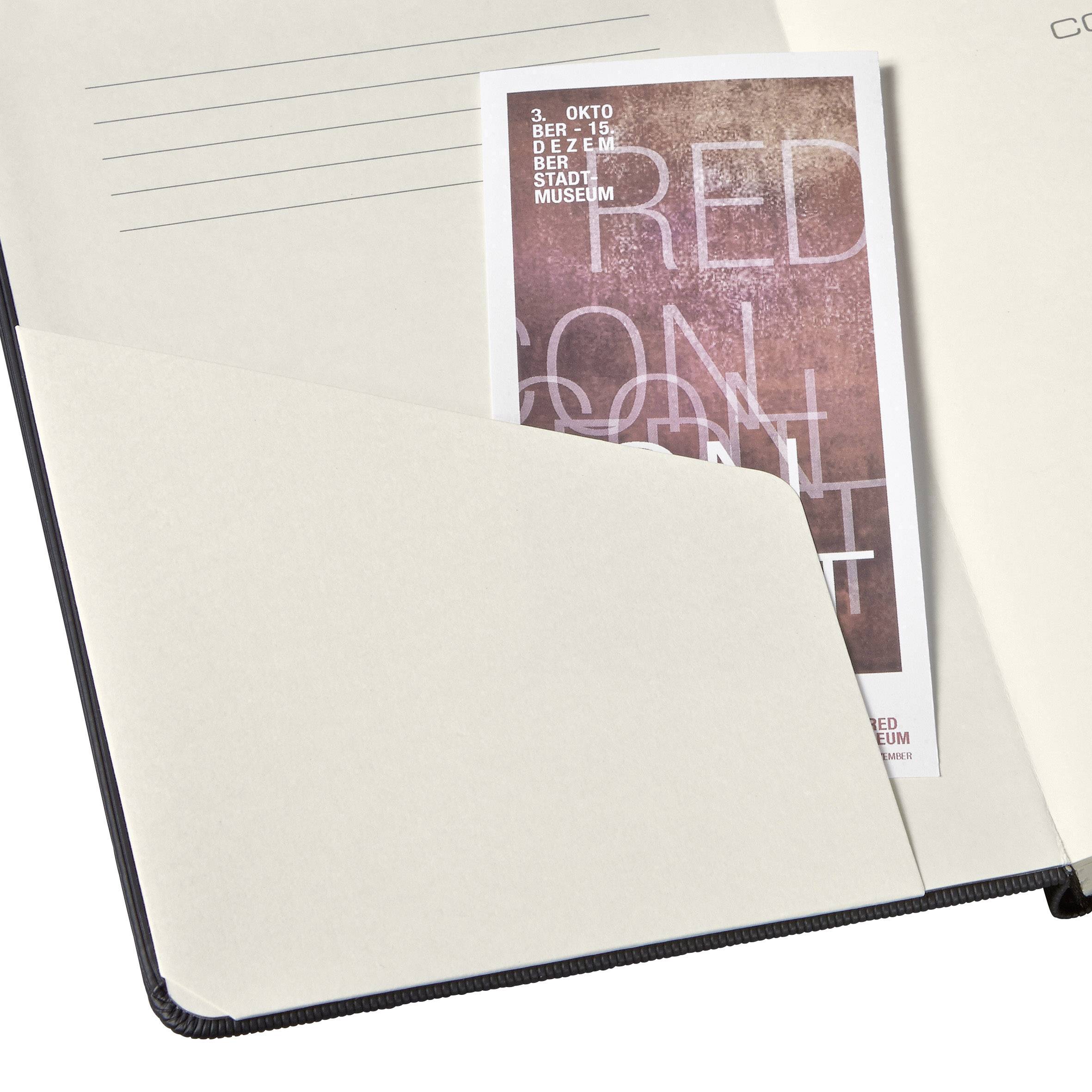 Ein Blatt Papier mit Linien und ein Foto eines Posters stecken in einem Ordner. Das Poster zeigt Daten für eine Veranstaltung im Oktober.