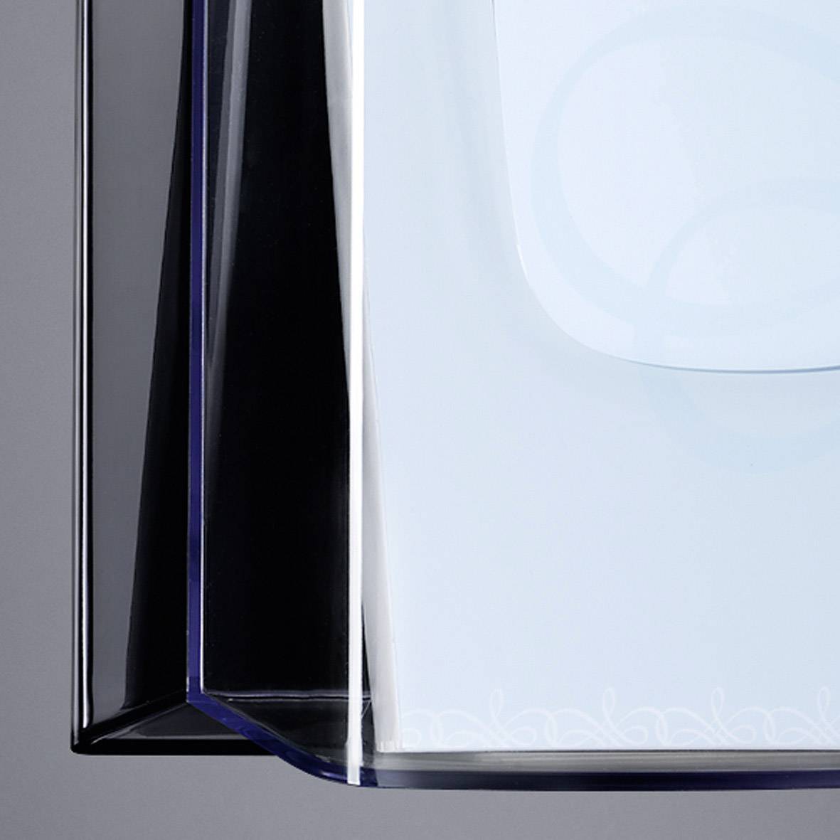 Eine geometrische, transparente Skulptur mit klaren Linien und geschwungenem Design, die Eleganz und Modernität ausstrahlt.