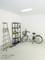 Eine Garage mit einer Leiter, einem Metallregal mit Gegenständen und einem Fahrrad. Oben ist eine Deckenleuchte angebracht.