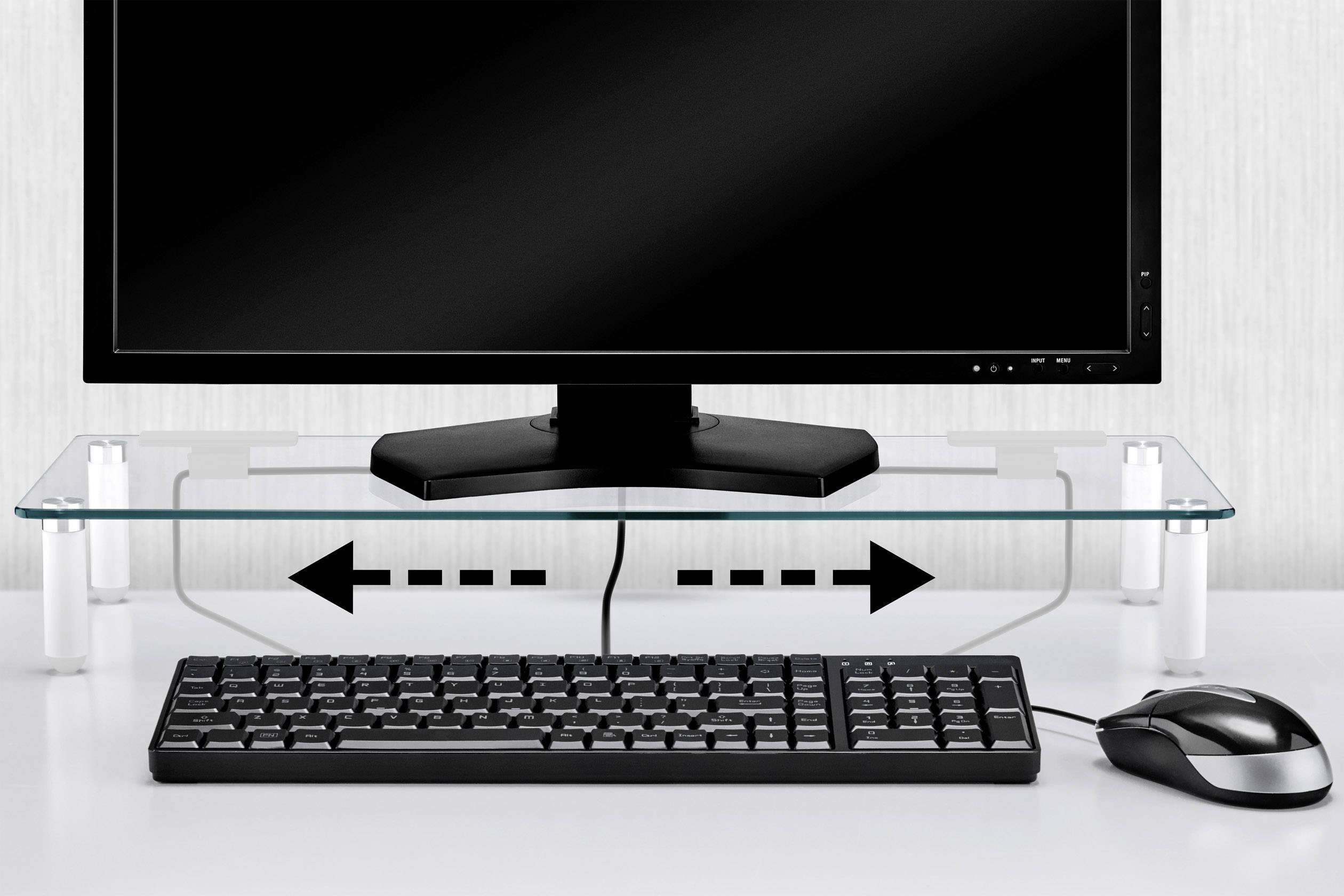 Ein Monitor steht auf einem Glasregal mit Pfeilen, die auf Stauraum darunter hinweisen. Tastatur und Maus sind darunter platziert.