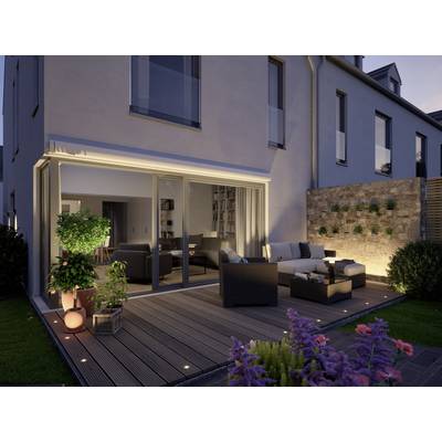 Moderne Terrasse bei Dämmerung mit gemütlichen Outdoor-Möbeln, Pflanzen und indirekter Beleuchtung vor einem modernen Wohnhaus.
