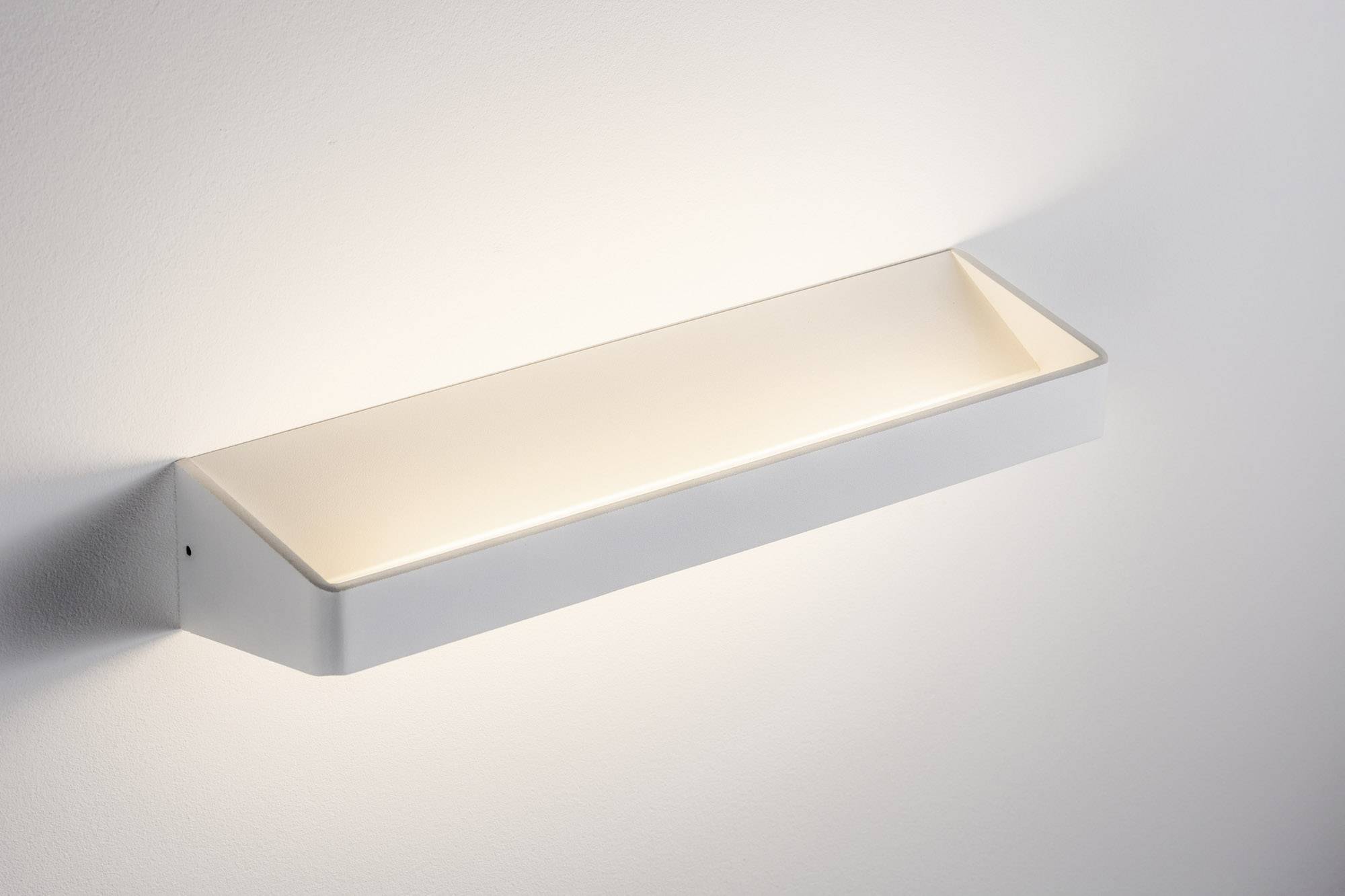 Eine weiße, rechteckige Wandleuchte mit indirektem, warmem Licht an einer weißen Wand.