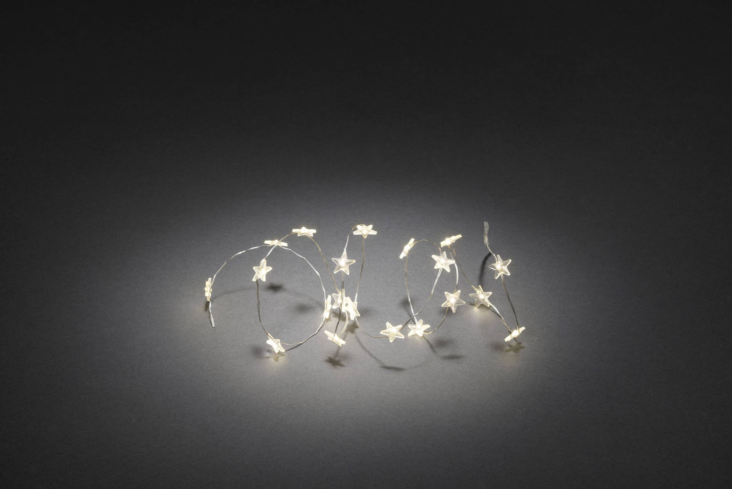 Eine Lichterkette mit kleinen, leuchtenden Sternen auf dunklem Hintergrund; dekorativ und erzeugt eine warme, stimmungsvolle Atmosphäre.