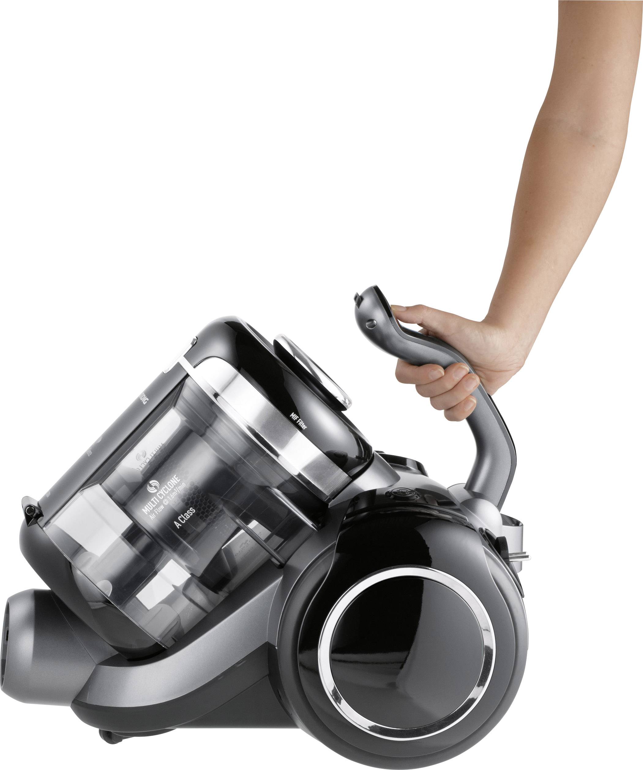 Eine Person hält einen schwarzen, beutellosen Staubsauger mit einem ergonomischen Griff.