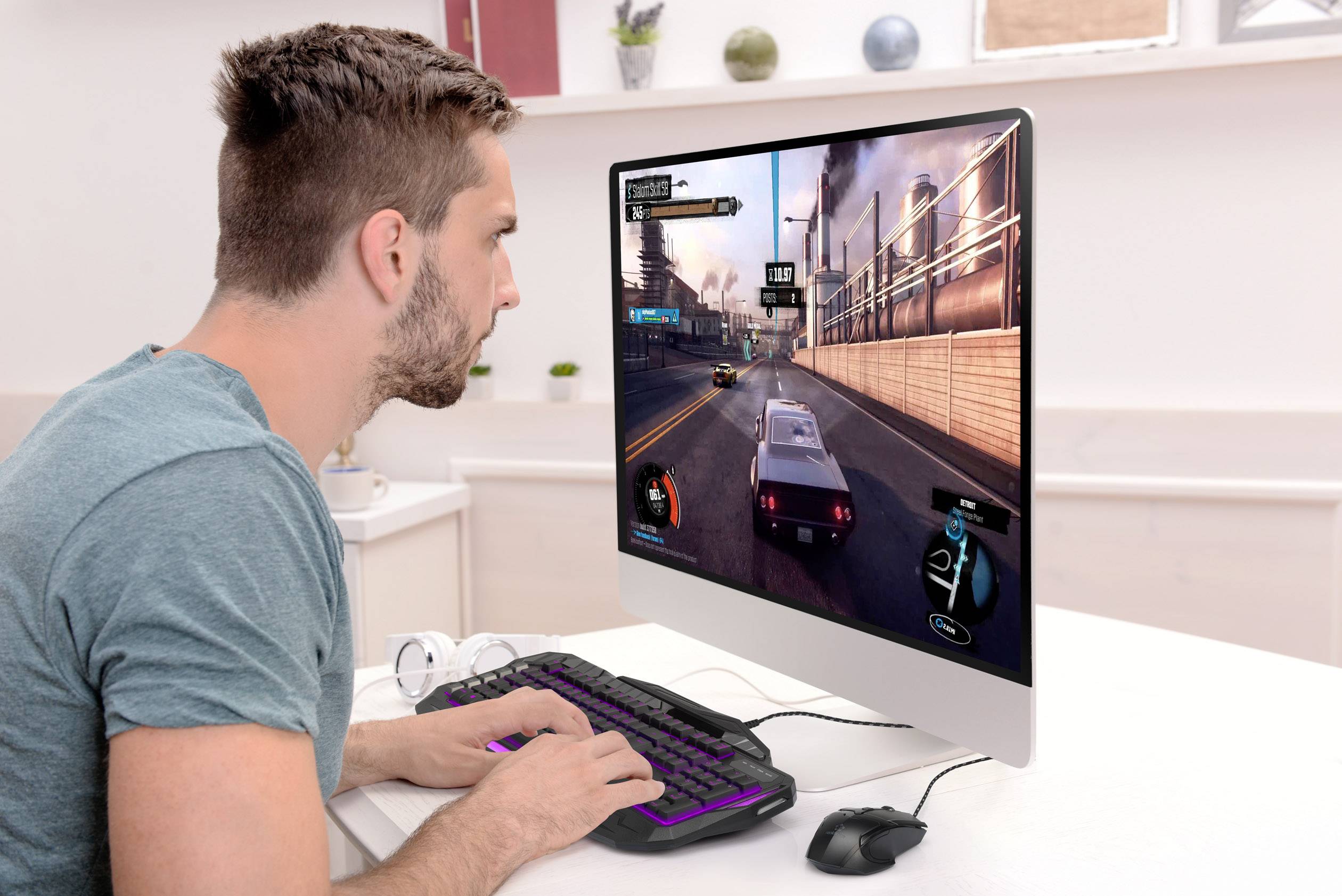 Ein Mann spielt ein Autorennspiel auf einem Computer. Der Monitor zeigt eine Straße, auf der er ein Rennauto steuert.