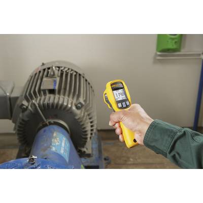 Eine Person hält ein gelbes Infrarot-Thermometer, das eine Temperatur von 148 Grad an einem industriellen Motor misst.