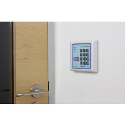 Eine Tür mit einem Zugangskontrollfeld mit numerischer Tastatur an der Wand.