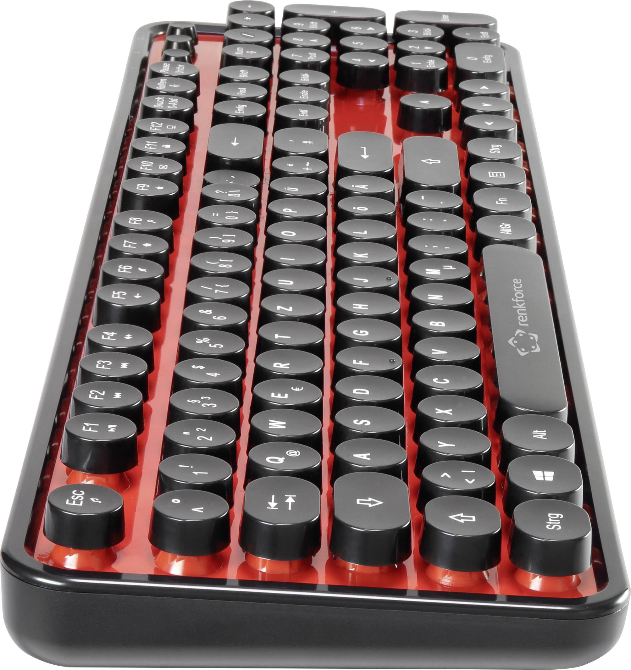 Schwarze Tastatur mit runden Tasten auf roter metallischer Oberfläche, zeigt modernes und stilvolles Design.