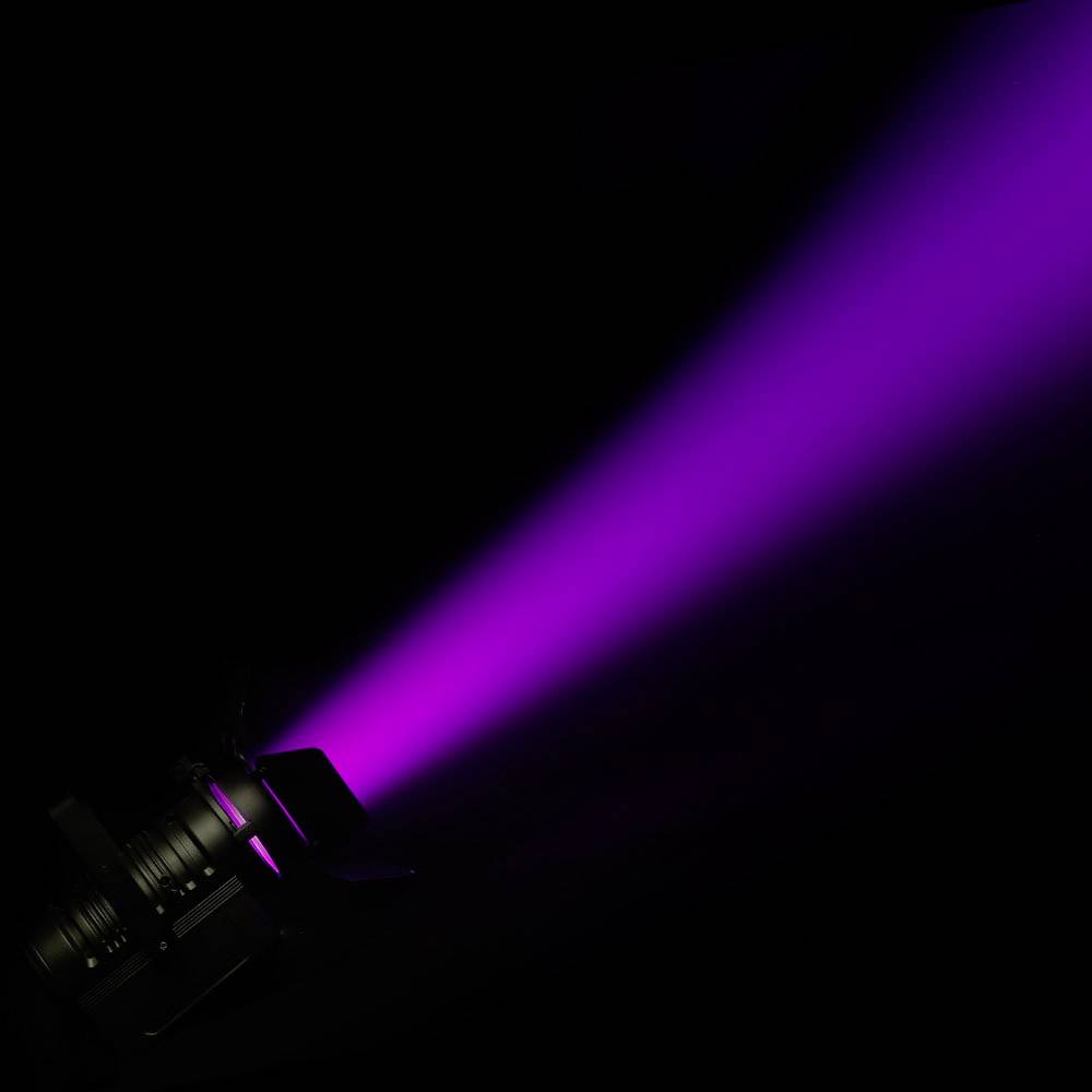 Ein Scheinwerfer projiziert einen intensiven, lila Lichtstrahl in die Dunkelheit, symbolisierend Fokus und Intensität.