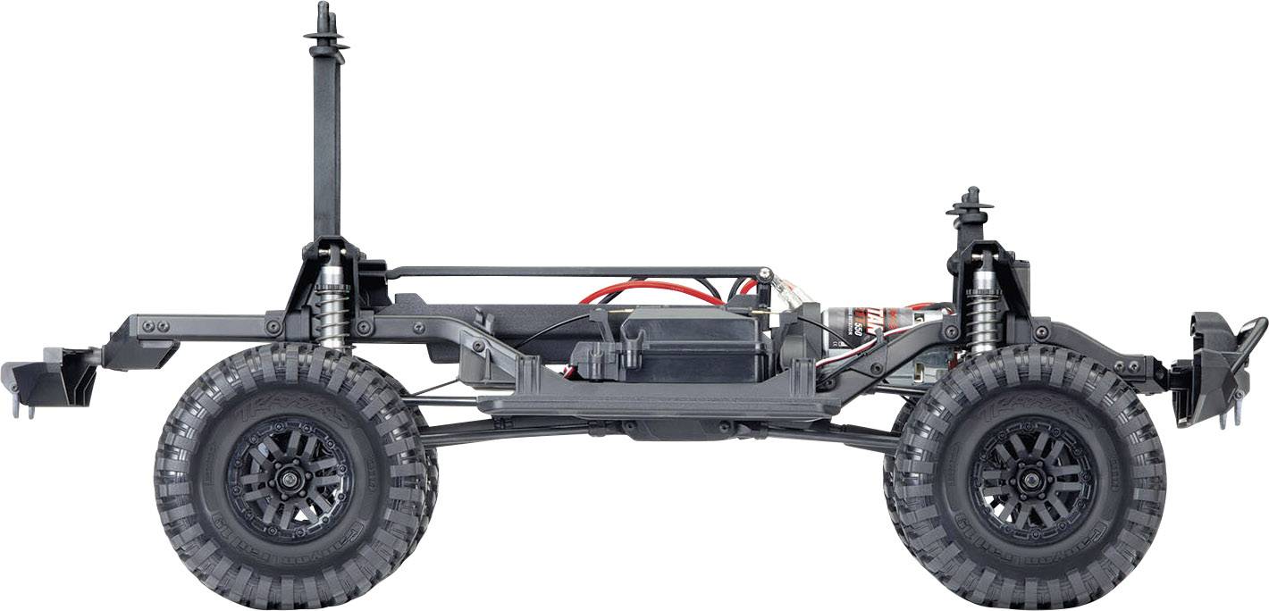 Seitlicher Blick auf einen schwarzen Geländewagen-Rahmen mit großen Rädern und sichtbarem Federungssystem auf einem weißen Hintergrund.